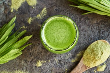 Bir bardak taze arpa suyu, kurutulmuş pudra, üst manzara.