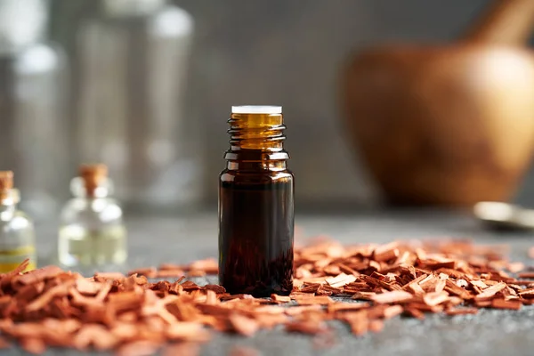 Dark Bottle Essential Oil Red Sandalwood Chips Aromatherapy Alternative Medicine — Stock Photo, Image