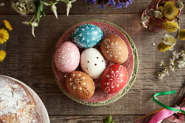 stock image Colorful Easter eggs decorated with wax with spring flowers and mazanec - traditional Czech sweet pastry similar to hot cross bun