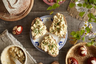 Kalan haşlanmış Paskalya yumurtalarından, hardaldan ve süzme peynirden yapılmış ekmek, üç dilim, üst manzara.