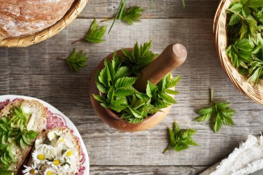 Genç gutweed yaprakları ya da tahta bir havan topunun içindeki yaşlı toprak yaprakları. İlkbaharda toplanan yabani yenilebilir bitki..