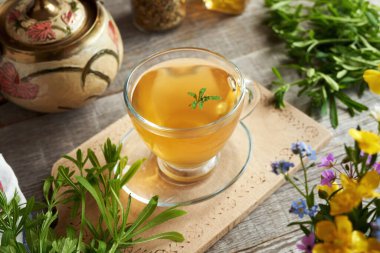 Bir fincan taze satırlı bitki çayı ve bahar çiçekleri.