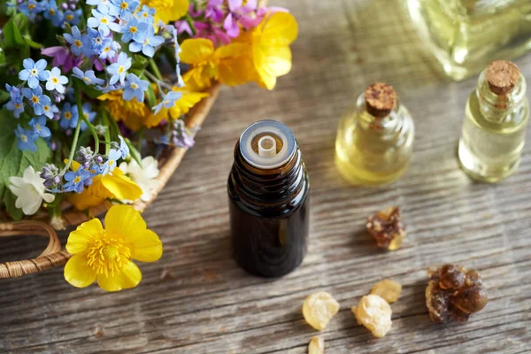 Een Donkere Fles Aromatherapie Essentieel Met Wierookhars Lentebloemen Achtergrond — Stockfoto
