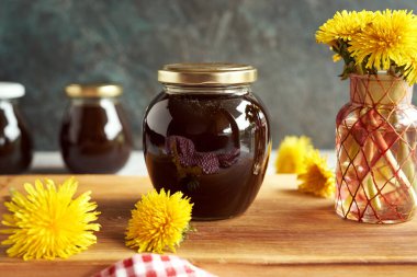 Masadaki cam kavanozda ev yapımı karahindiba şurubu.