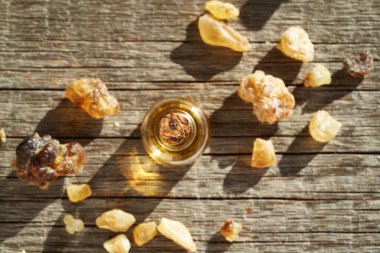 Ahşap arka planda Boswellia reçinesi olan bir tütsü şişesi.