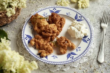 Kızarmış mürver çiçekleri de masada bir tabakta kosmatice olarak adlandırılır.