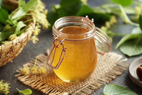 Een Kruik Honing Met Linde Bloemen Een Mand Een Tafel — Stockfoto
