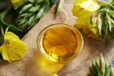 Tahta bir masada bir kase çuha çiçeği yağı. Sağlıklı besin takviyesi.