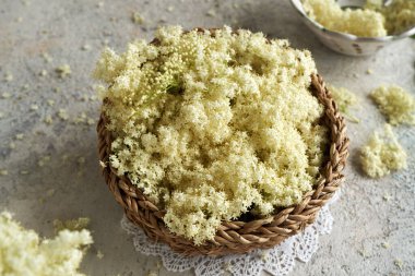 Mürver çiçekleri hasır sepetin içinde baharda bir masada.