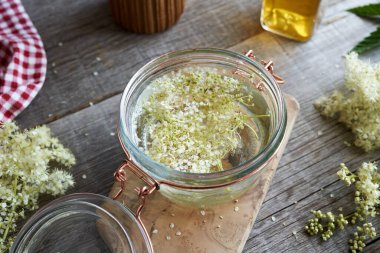 Bitkisel tütünü hazırlamak için, alkol ve çayırçiçeği dolu cam bir kavanoz.