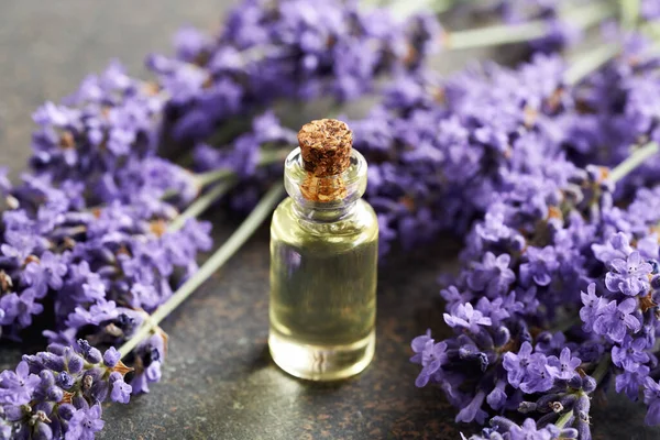 一瓶透明的芳香疗法精油 桌上有新鲜的紫色薰衣草花 — 图库照片