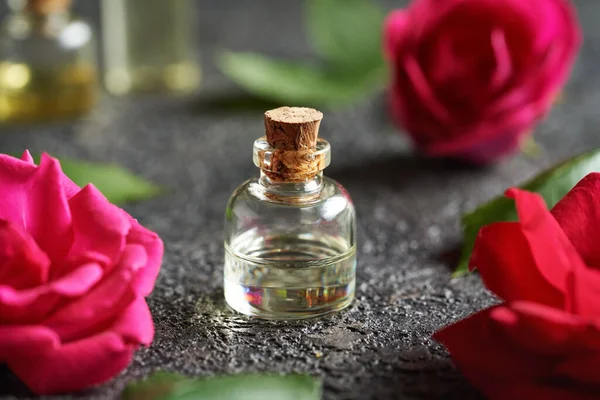 Бутылка Эфирного Масла Свежими Цветами Красной Розы Листьями Темном Фоне — стоковое фото