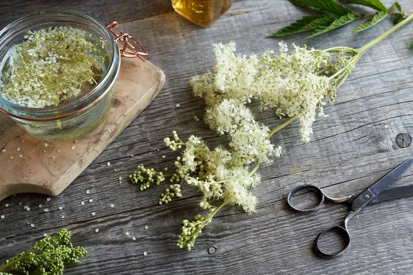 新鲜的草地甜甜的或Filipendula花在桌子上 与一罐草药药水 — 图库照片