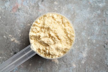 Bir ölçü kabındaki beyaz protein tozunun üst görünümü