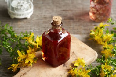 Bir şişe ev yapımı kırmızı yağ. St. John 's otundan yapılmış.