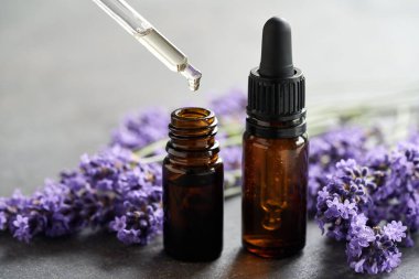 Taze lavanta çiçekleri ve bir damlacıkla iki şişe aromaterapi gerekli yağ.