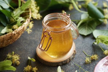 Cam kavanozda taze ıhlamur ya da Tilia çiçekleri olan bal.