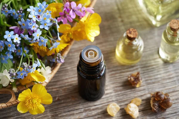 Masasında Tütsü Bahar Çiçekleri Olan Esaslı Bir Aromaterapi Şişesi — Stok fotoğraf