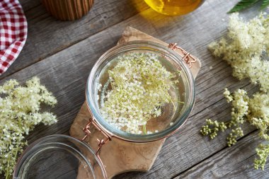 Ahşap bir masada cam bir tentür kavanozu, üst manzara.