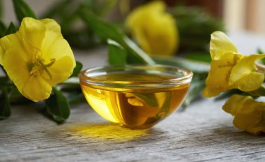 Sağlıklı yağ - Taze Oenothera biennis çiçekleriyle dolu cam bir kasede akşam çiçeği yağı