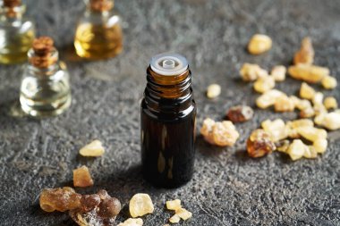 Masasında tütsü reçinesi olan bir yağ şişesi.