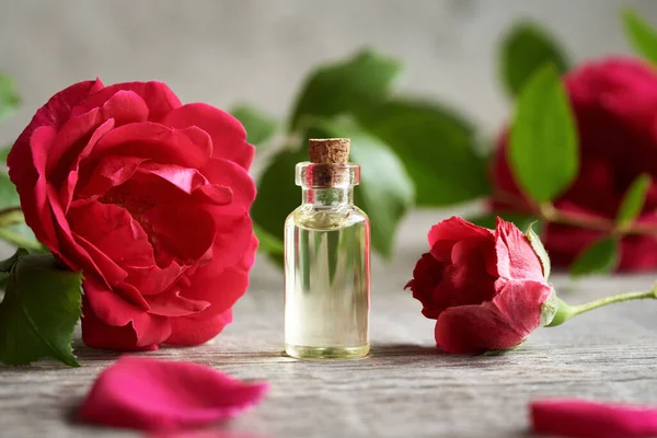 Aromaterapi masasında kırmızı gül çiçekleri olan gerekli yağ.