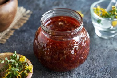 Taze çiçek açmış St. John otundan şifa yağı hazırlığı