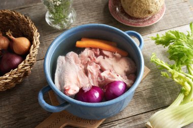 Ev yapımı kemik suyu veya çorba - tavuk ve taze sebzeler bir tencere suda.