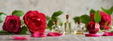 Yatay pankart ve aromaterapi şişeleri taze gül çiçekleri ile gerekli yağ