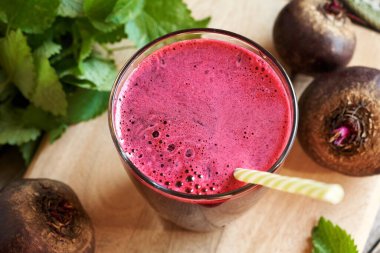 Bir fincan taze sıkılmış kırmızı pancar suyu ve pipet.