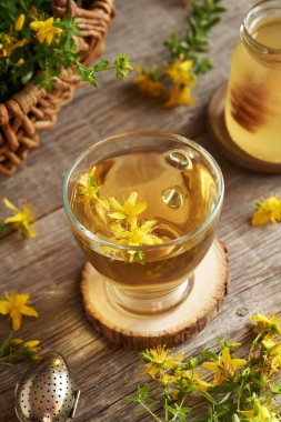 Bir fincan taze St. John otu ya da Hypericum çiçekli bitki çayı.