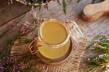 Bir kavanoz bitkisel şurup ve taze yabani kenevir çiçekleri