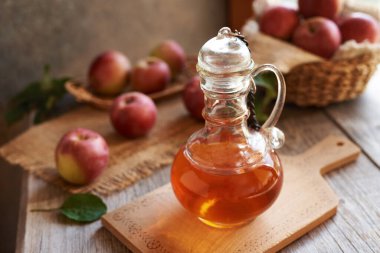 Elma sirkesi cam bir sürahide taze kırmızı elmalarla