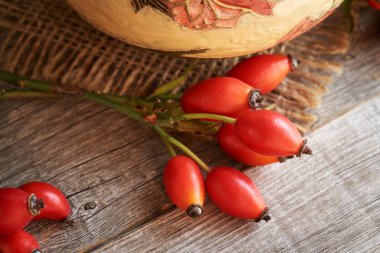 Tahta bir masanın üzerinde Rosehips, yakın çekim
