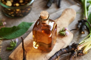 Ahşap bir masada bir şişe kozalak tentürü.