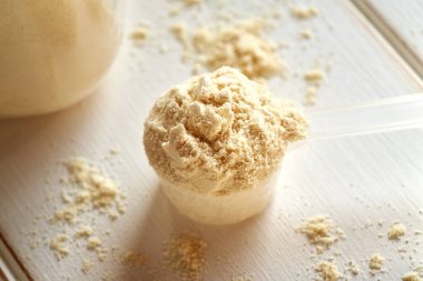 Parlak bir masada bir kepçe süt tozu.