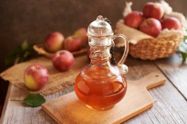 Elma şarabı sirkesi. Ahşap bir masada cam bir şişede.