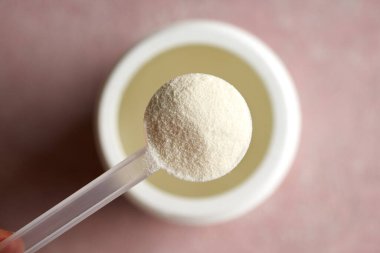 Plastik bir kepçedeki kolajen tozu, üst görünüm.