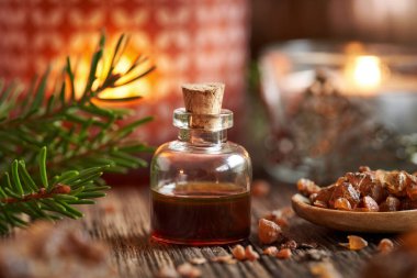 Mum ve Noel süsüsüyle bir şişe reçine yağı.