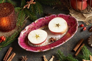 Ortasında yıldız şeklinde ve Noel süslemesi olan taze elma.