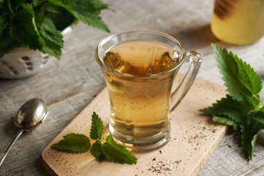 Masadaki cam bardakta ısırgan otu çayı.