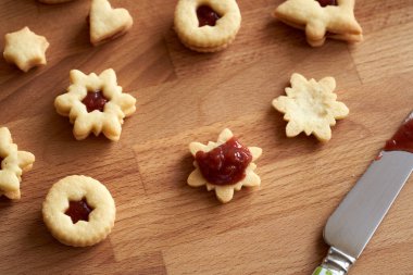 Geleneksel Linzer Noel kurabiyelerini kırmızı çilekli marmelatla doldurmak.