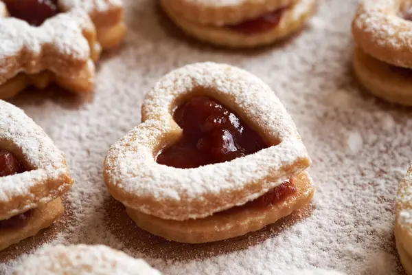 Ev yapımı bir Linzer Noel kurabiyesinin kapanışı içinde çilek reçeli ve şekerle kaplanmış.