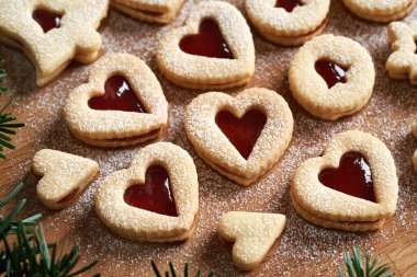 Kalp şeklinde Noel kurabiyeleri. Çilek reçeli ve köknar ağacı dallarıyla dolu.