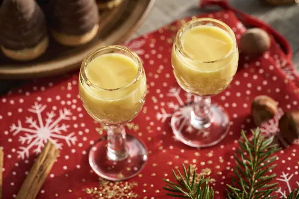 İki shot bardakta kremalı eggnog, Noel kurabiyeleri ve dekorasyon.