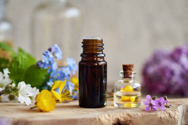 Bahar otları ve leylak çiçekleri ile gerekli yağ şişeleri