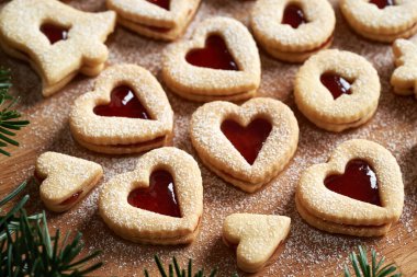 Kalp şeklinde ev yapımı Linzer Noel kurabiyeleri, kırmızı marmelatla doldurulmuş ve şekerle kaplanmış.