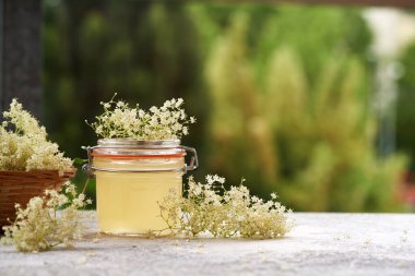 Bir kavanoz yaşlı çiçek şurubu açık bir masada, kopyalama alanı ile