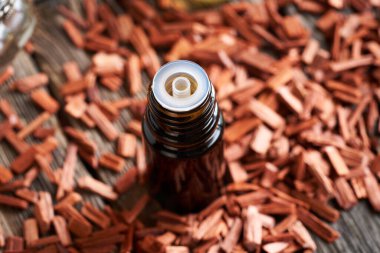 Kırmızı sandal ağacı parçalı koyu bir yağ şişesi.