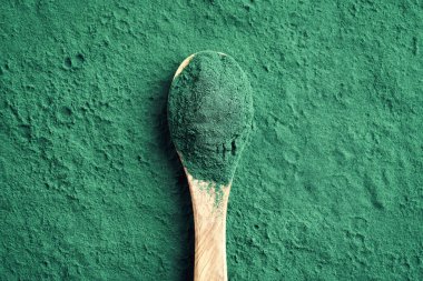 Fotokopi alanı olan bir kaşıkta yeşil spirulina yosunları tozu.